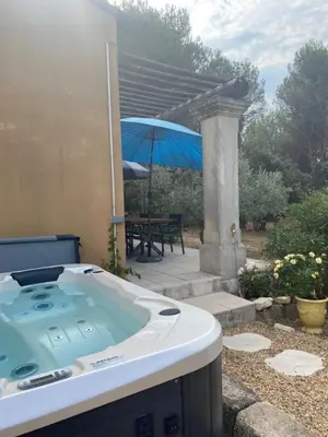 a bath tub in a yard with a table and an umbrella at Maison de famille au coeur du Luberon in Mérindol