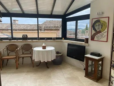 a living room with a table and a tv at La Cour Carrée in Rustrel