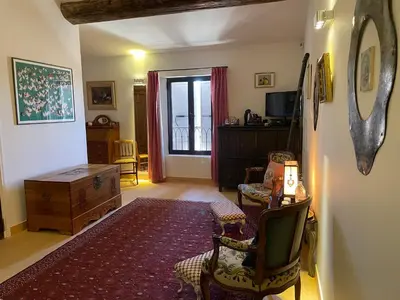 a living room with a table and chairs and a room at La Cour Carrée in Rustrel