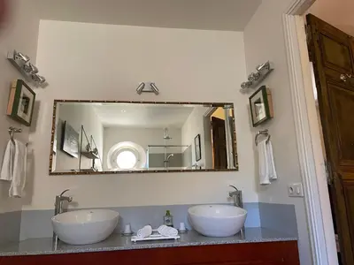 a bathroom with two sinks and a large mirror at La Cour Carrée in Rustrel