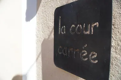 a black sign with the words la court carré at La Cour Carrée in Rustrel