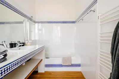 a white bathroom with a tub and a sink at La Pastorale in Lagnes