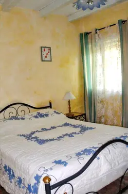 a bedroom with a bed with a blue and white blanket at Villa charmante à Dauphin avec piscine privée in Dauphin