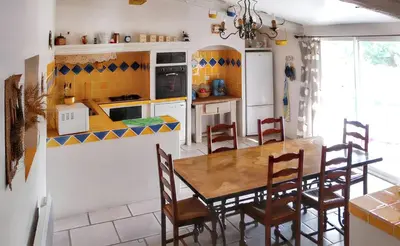 a kitchen with a table and chairs in a room at Villa charmante à Dauphin avec piscine privée in Dauphin
