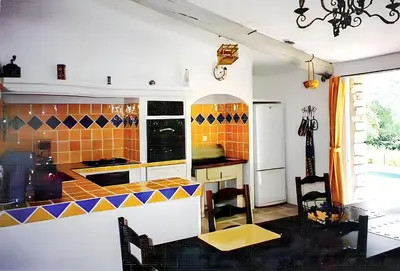 a kitchen with orange and blue tile on the wall at Villa charmante à Dauphin avec piscine privée in Dauphin