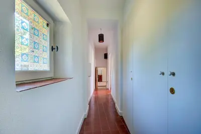 a hallway with a window and a tile floor at Les Chambres du Perussier in Cucuron