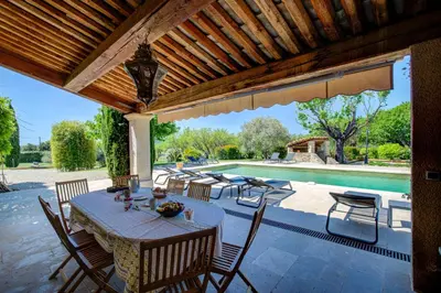 a patio with a table and chairs and a pool at Les Chambres du Perussier in Cucuron