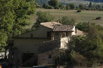 an old stone house with a field behind it at La Fontaine in Simiane-la-Rotonde