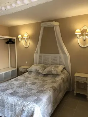a bedroom with a white bed with a canopy at Provence Luberon Bonnieux location gite chez Marcelle in Bonnieux