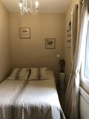 a bedroom with a bed with a chandelier and a window at Provence Luberon Bonnieux Location Gite Chez Basile in Bonnieux
