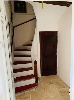 a hallway with stairs and a wooden door at Stone house in Isle-sur-la-Sorgue in LʼIsle-sur-la-Sorgue