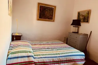 a bedroom with a bed and a dresser and a picture at Stone house in Isle-sur-la-Sorgue in LʼIsle-sur-la-Sorgue