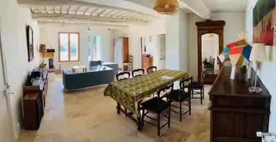 a living room with a table and chairs at Stone house in Isle-sur-la-Sorgue in LʼIsle-sur-la-Sorgue