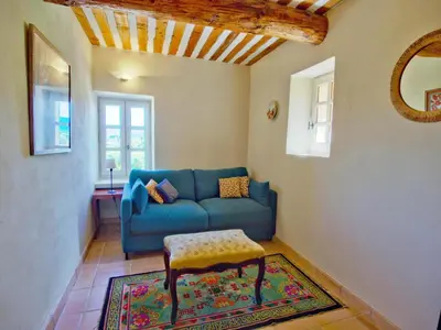 a living room with a blue couch and a table at Chez Manon in Apt