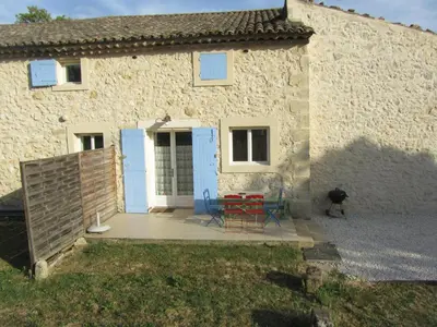 a stone house with two chairs and a table at Maison provençal avec PISCINE in Cavaillon