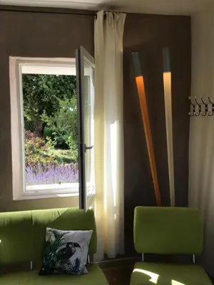 a living room with a green couch and a window at Mas du Figuier Oppede Luberon in Oppède