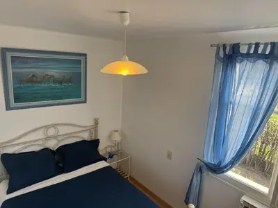 a bedroom with a bed and a window with blue curtains at Relaxing Provence Hideaway in Carpentras