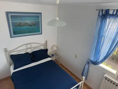 a bedroom with a blue bed and a window at Relaxing Provence Hideaway in Carpentras