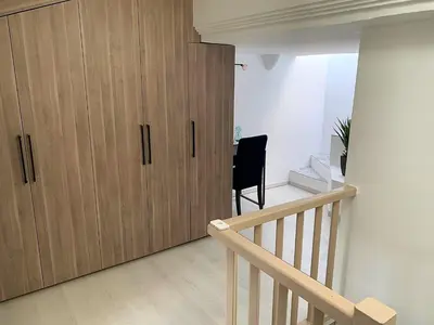 a large wooden cabinet in a room with a staircase at LE FOCH in Aix-en-Provence