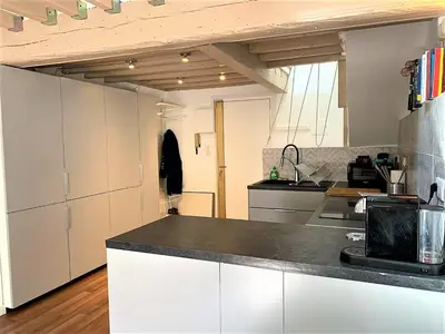 a kitchen with white cabinets and a black counter top at LE FOCH in Aix-en-Provence