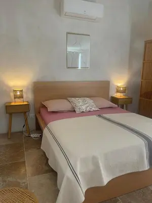 a bedroom with a large bed with two tables at Lou Mas in Gordes