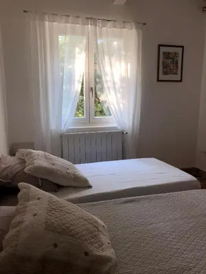 two beds in a bedroom with a window at Lou Mas in Gordes