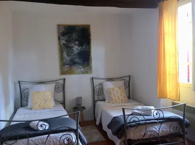 a bedroom with two beds and a window at LA MAISON D’ALICE in Sault-de-Vaucluse