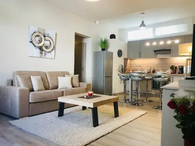 a living room with a couch and a table at Les volets rouges in Cavaillon
