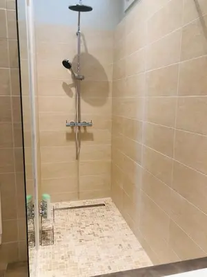 a shower in a bathroom with a glass door at Les volets rouges in Cavaillon