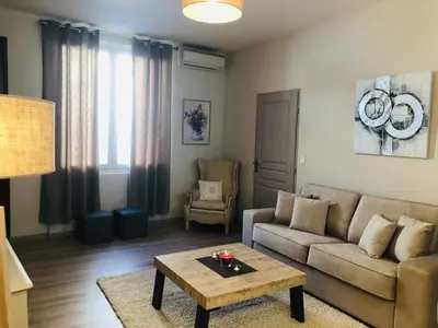 a living room with a couch and a coffee table at Les volets rouges in Cavaillon