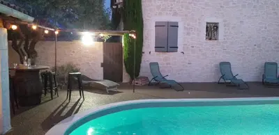 a swimming pool in a house with chairs and a table at Un petit coin de paradis in Modène