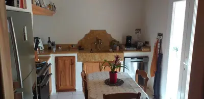 a kitchen with a table with a plant on it at Un petit coin de paradis in Modène