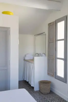 a white bathroom with a sink and a mirror at Villa Vagabonde in Gordes