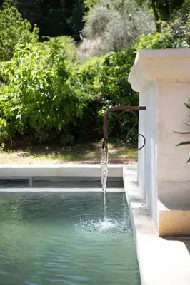 a water fountain hooked up to a wall at Les Cabanes de la Fontaine in Lacoste
