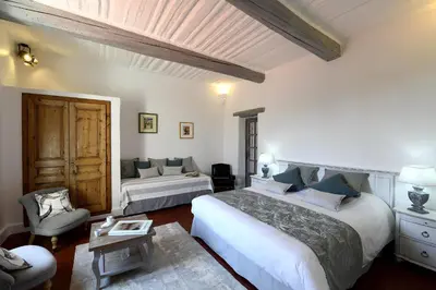 a large bedroom with two beds and a couch at Bastide Des Demoiselles in Roussillon