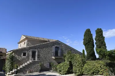 an old stone building with trees in front of it at Bastide Des Demoiselles in Roussillon