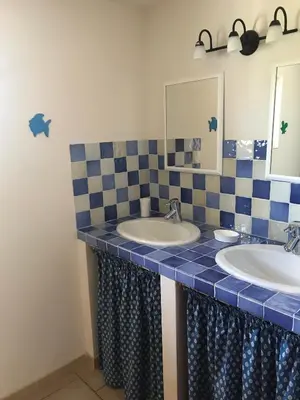 a bathroom with two sinks and a mirror at La Bastide de l'Olivier in Flassan