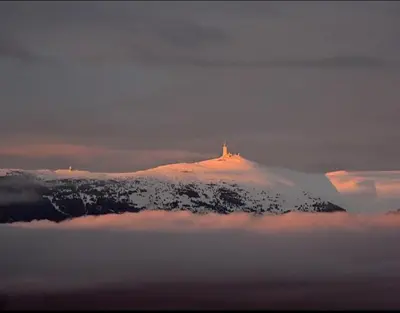 a snow covered mountain with a cross on top of it at La Bastide de l'Olivier in Flassan