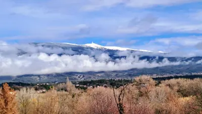 a snow covered mountain with clouds in front of it at La Bastide de l'Olivier in Flassan