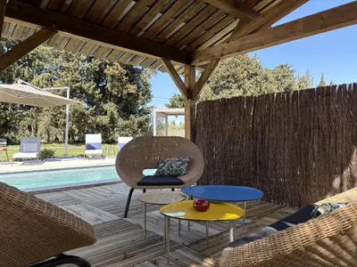 a group of chairs and an umbrella next to a pool at Mas d'Auseu in Cavaillon