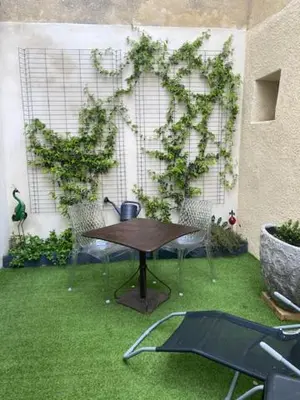 a patio with a table in the grass at Maison de charme Isle sur la Sorgue in LʼIsle-sur-la-Sorgue