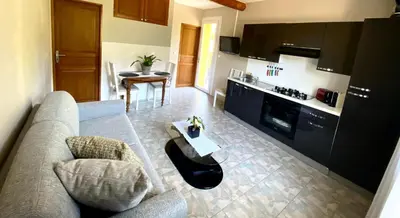 a living room with a couch and a table at Vue panoramique sur le château,montagne et grottes in Fontaine-de-Vaucluse