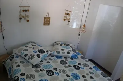a bed with blue and white pillows on it at Studio charmant au calme in Aix-en-Provence
