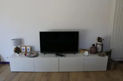 a flat screen tv sitting on top of a white cabinet at Studio charmant au calme in Aix-en-Provence