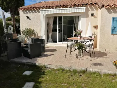 a patio with a table and chairs on it at La perle des Alpilles Résidence les MYRTILLES in Eyguières
