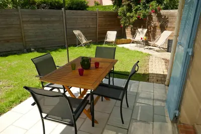 a wooden table and chairs on a patio at Chez Marielle in LʼIsle-sur-la-Sorgue