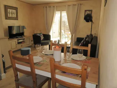 a dining room table with two chairs and a table with wine glasses at Chez Marielle in LʼIsle-sur-la-Sorgue