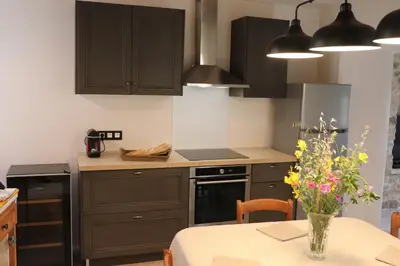 a kitchen with dark brown cabinets and a table with flowers at L'Ensoleillée in Ménerbes