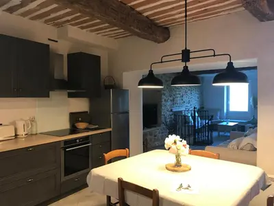 a kitchen and dining room with a table with flowers on it at L'Ensoleillée in Ménerbes