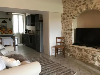 a living room with a couch and a flat screen tv at L'Ensoleillée in Ménerbes